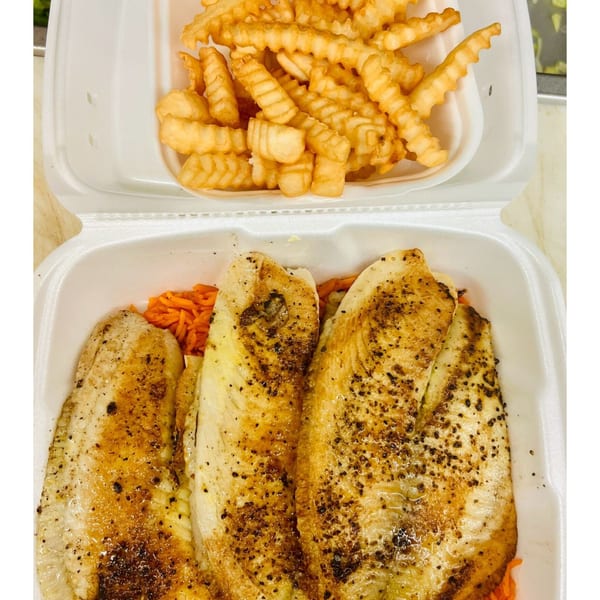 Three seasoned fish fillets over rice with a side of crinkle-cut fries in a takeout container.